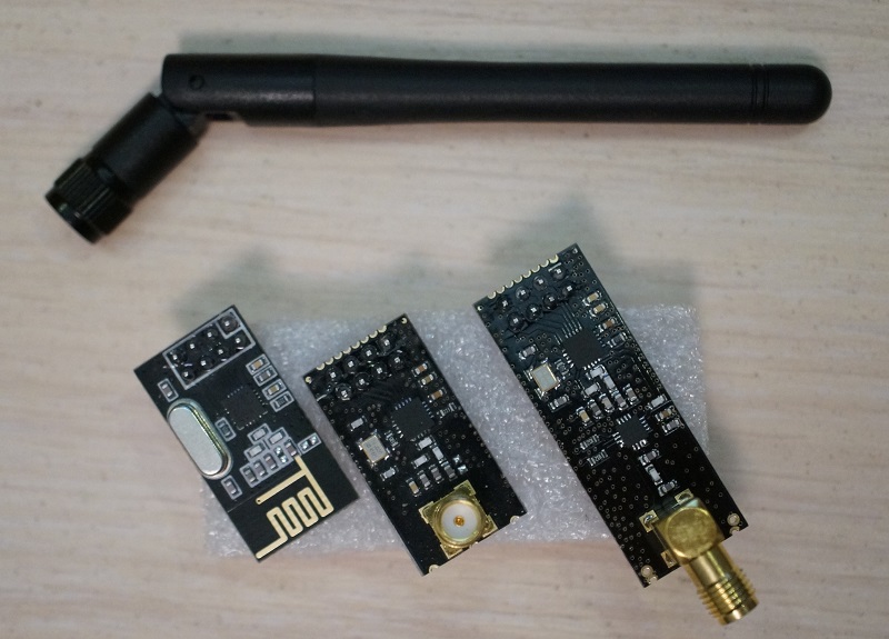 Слева-направо: модуль 1мВт с антенной в виде дорожки меди на плате, модуль 1мВт с sma-выходом на антенну, модуль 100мВт с sma-выходом на антенну и чипом усиления. Сверху - sma-антенна 2,4ГГц 2dBi